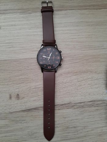 Montre homme noire et argentée, bracelet marron, montre a quartz