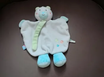 Ours sucre d orge doudou "Doumou"
plat
blanc
étoiles brodées
pattes bleues
attache tétine vert