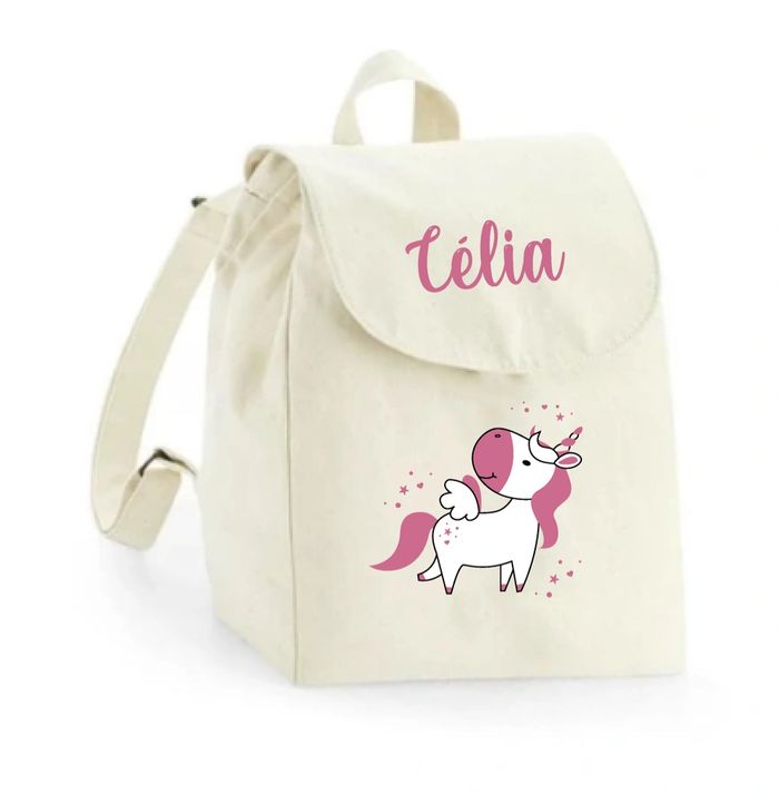Sac à dos maternelle personnalisé - Motif ânesse fleurie  Ce sac à dos en coton bio est illustré d’une petite ânesse trop craquante, avec une fleur rose sur la tête et un joli papillon bleu. Personnalisé avec le prénom de votre enfant, il est parfait pour