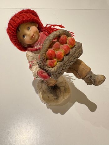 Bibelot représentant un enfant tenant un panier de pommes