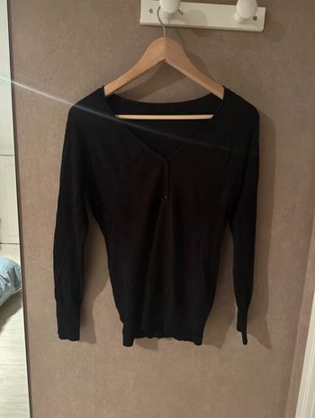 Pull noir avec des boutons sur le devant