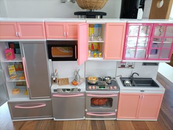 Cuisine équipée gris et rose avec frigo, lave vaisselle, évier, four, micro ondes et nombreux accessoires 
