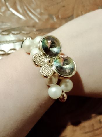 bracelet élastique noire perles blanches et métal doré.