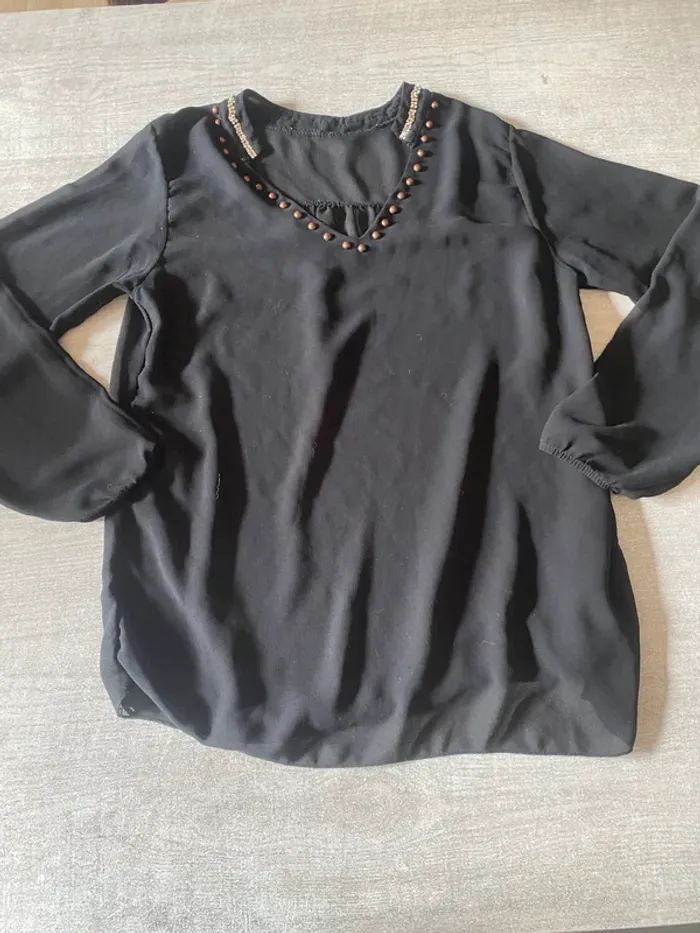 Haut noir fluide à perles – col V élégant et féminin