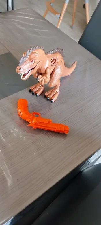 Jeu dinosaure avec pistolet. Fonctionne à piles. Très bon état