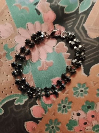 bracelet en strass noires sur métal foncé.