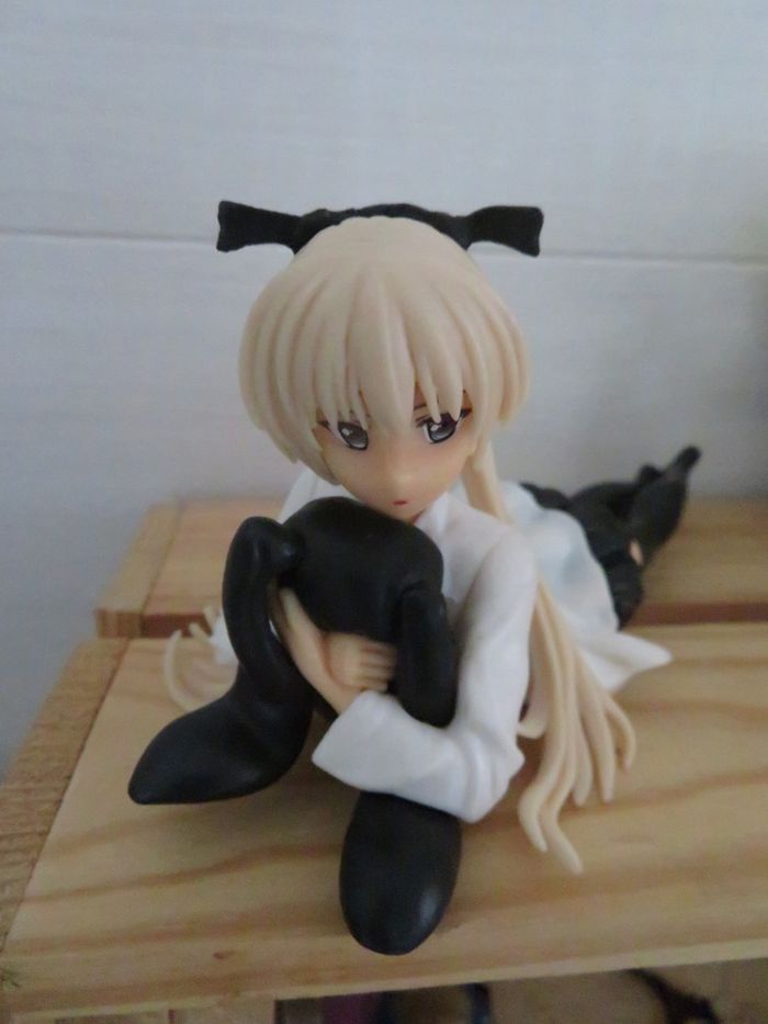 Figurine manga fille allongée avec sa peluche