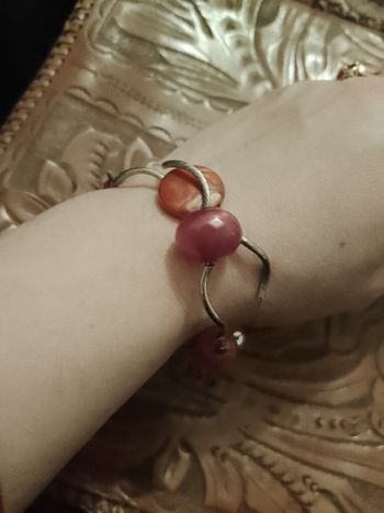 bracelet en métal argenté et perles plastique roses.