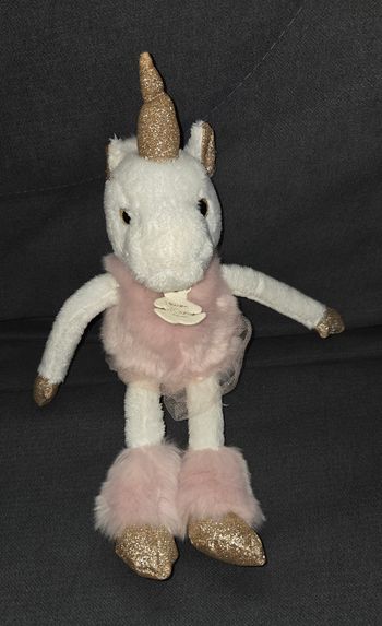 Doudou peluche Licorne blanche rose et doré 25 cm -  Tutu - Histoire d'oursDoudou peluche Licorne en velours de couleur blanche et en velours fourrure de couleur rose. 
Tutu de couleur rose autour de sa taille.
Corne , intérieur des oreilles et le bo