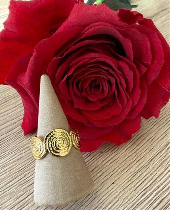 Bague ajustable dorée avec une suite de médaillons circulaires en acier inoxydable 