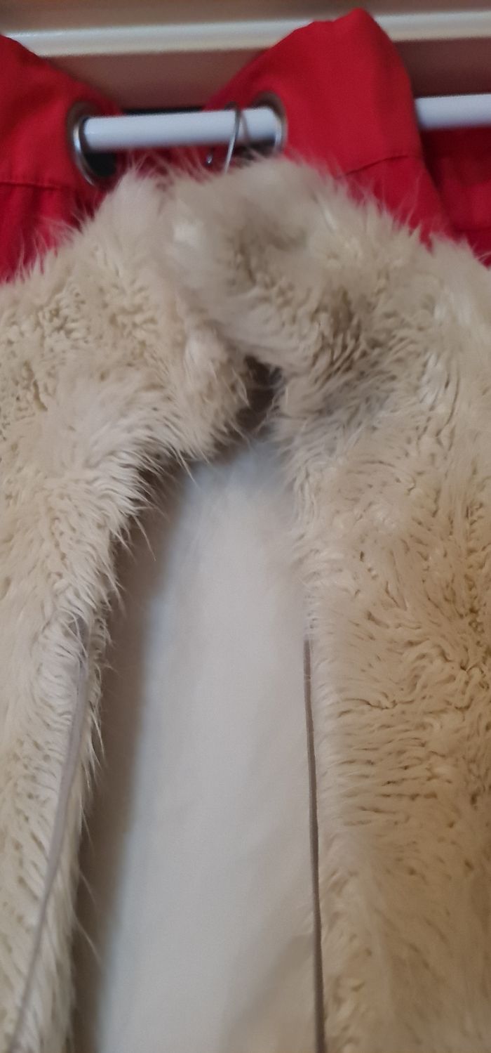 Veste fourrure synthétique sans manches avec petit laçage devant.