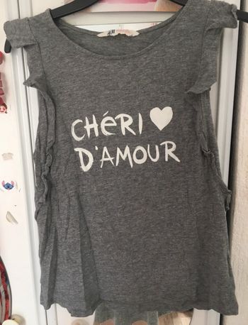 t-shirt gris chiné avec inscription blanche. Sur les manches il y a des volants H&M 12/14 ans