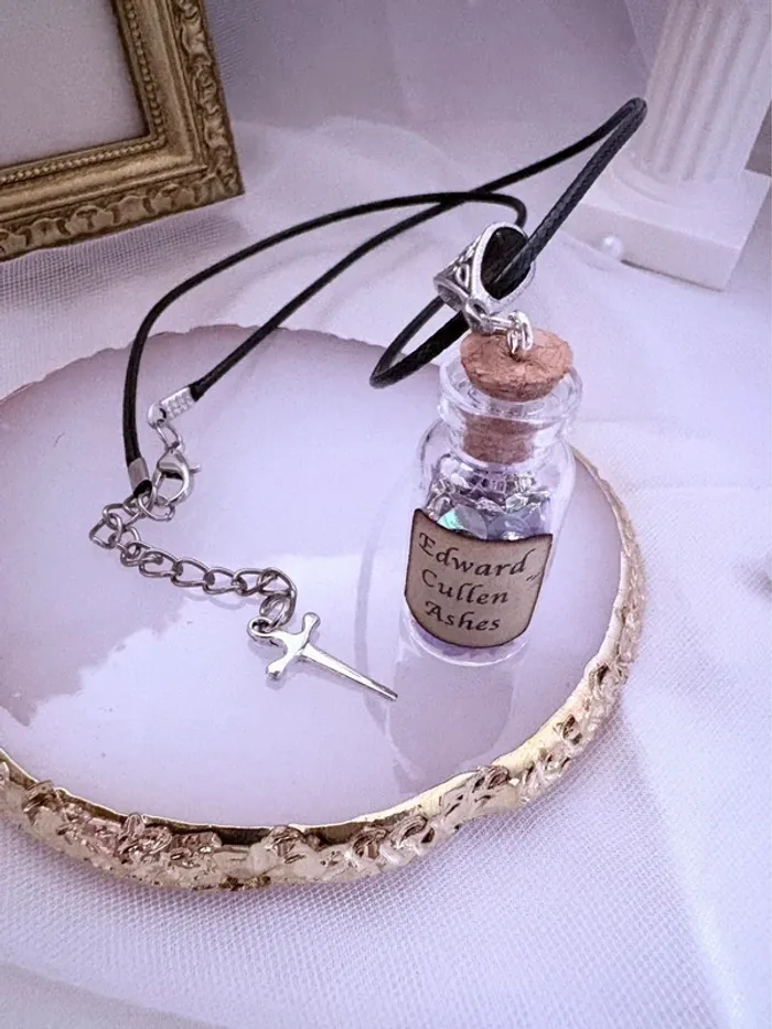 Collier en lien noir avec fiole en verre et breloque poignard