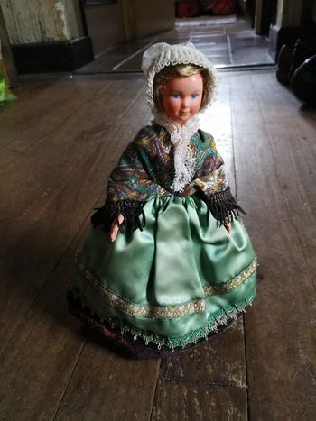 Poupée régionale de collection en robe rouge tablier vert