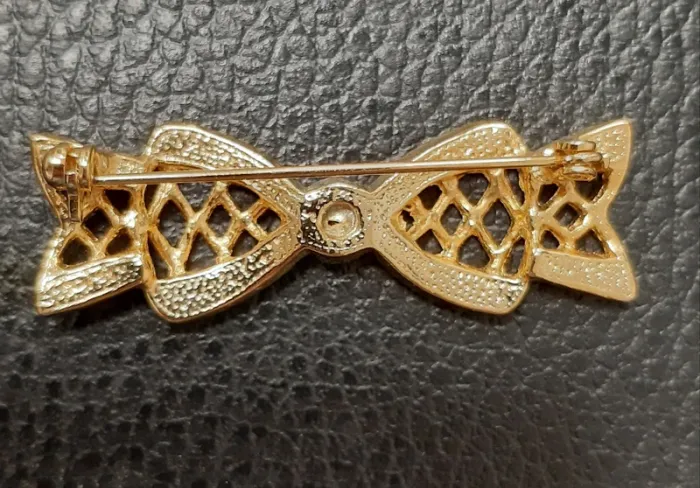 Très belle broche en metal doré et strass en forme de noeud - photo numéro 2