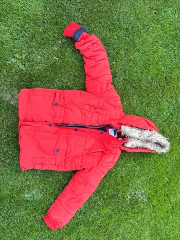 Manteau  Okaidi  6 ans  Un petit accro de chaque côté des manches.