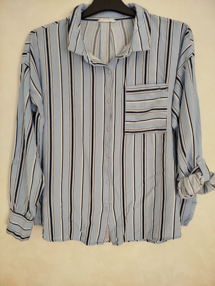 Chemise bleu ciel rayures marine. Très bon état et propre. Cache cache.