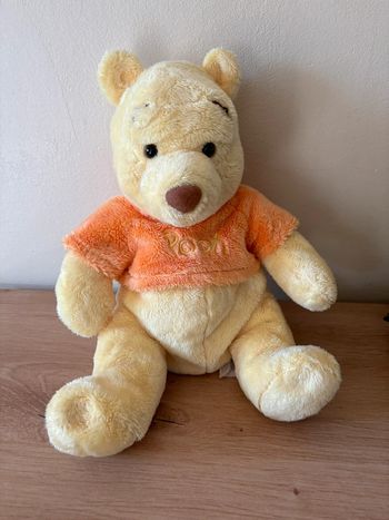 Doudou Winnie l ourson jaune pull orange pooh Disney store
