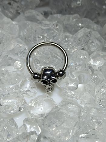 Piercing anneau captif avec tête de mort perlée teton poitrine sein