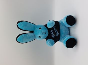 Peluche lapin bleu tee-shirt noir Play Bunny yeux noirs 26 cm assis