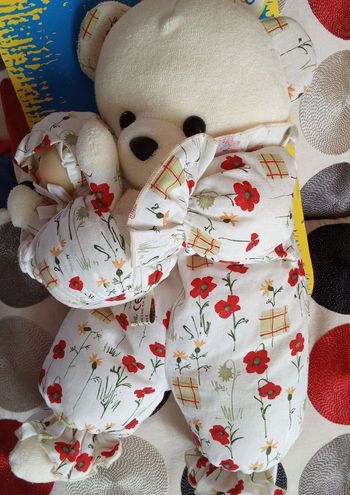 Doudou ours ourson peluche de la marque Minouche vintage ancien 1997 des années 90 eighties 1993 blanc avec sa luciole neuf blister carton tissu jaunis  30 ans  fleurs rouges floral fleuri coquelicots  posture debout 