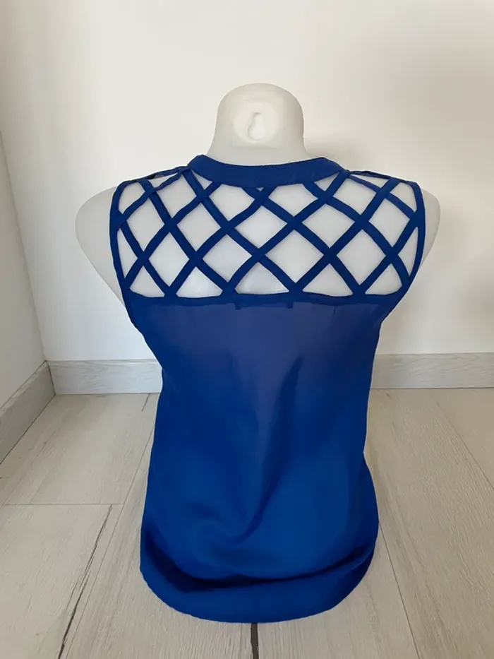 Blouse bleue sans manche dos quadrillé