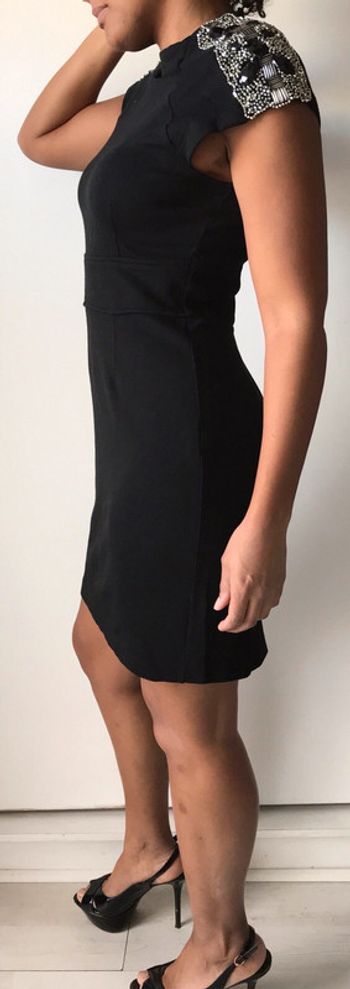 Petite robe noire avec épaulettes et détail bijoux sur les épaules