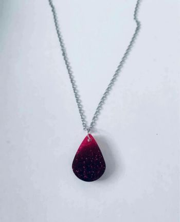 Le pendentif est fait main sur une résine noire avec paillettes roses 🥰