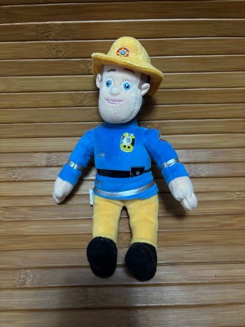 Doudou bonhomme jaune bleu sam le pompier 