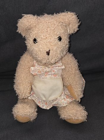 Doudou peluche ours robe fleuri - Tablier a brodé- DMCDoudou peluche ours en velours poils de couleur beige .
Ours qui mesure en position assise 20 cm .
Vêtue d'une robe en tissu fleuri et par dessus tablier a brodé.