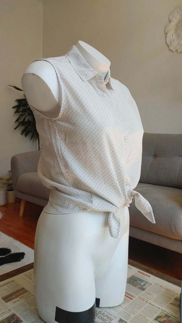 Chemise sans manche à pois noir sur fond blanc noué à la taille