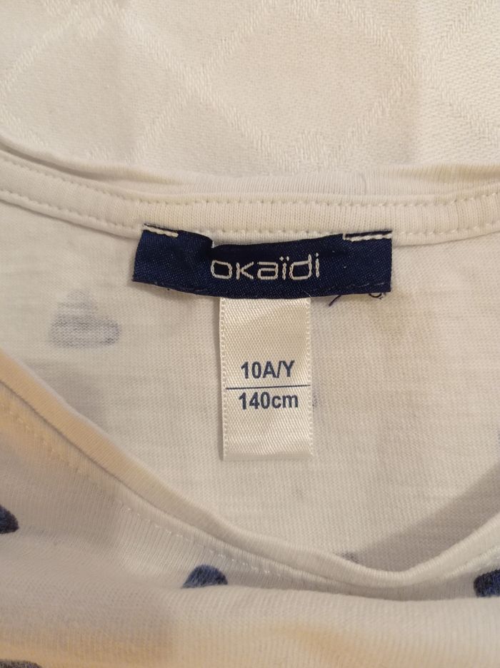 Marque Okaïdi taille 10 ans 140 cm polo manches courtes avec petit revers en Manche couleur blanc avec des petits cœurs bleus voir photos - photo numéro 2