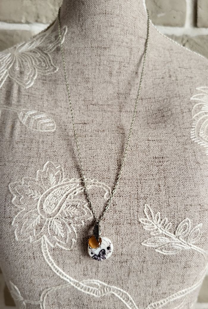 Collier sautoir argenté avec breloque
thème papillon
