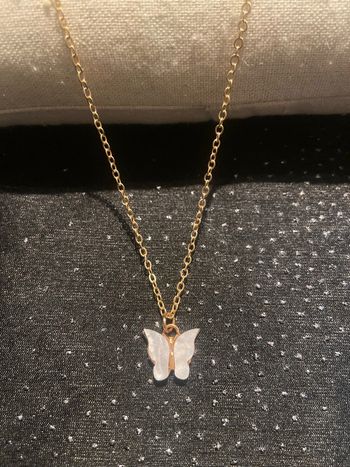 collier doré pendentif papillon blanc