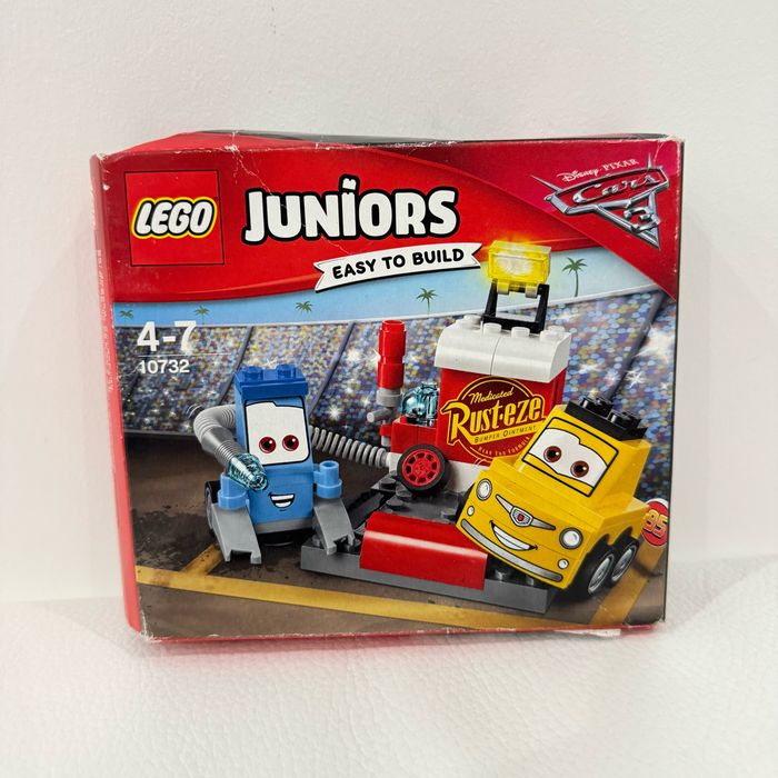 Lego Juniors 10732 - L'arrêt Au Stand De Guido Et Luigi - Boite neuve, scellée mais un peu abîmée (voir photos).