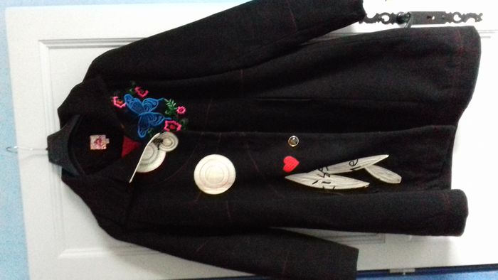 Manteau noir avec broderies florales devant et dans le dos. "By Design"