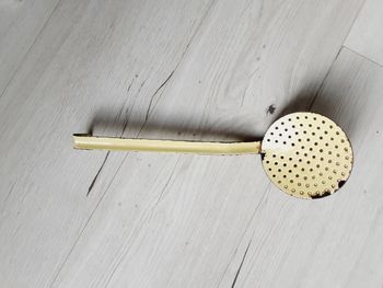 Ancien écumoire en fer couleur jaune 11 cm de diamètre et manche 25 cm