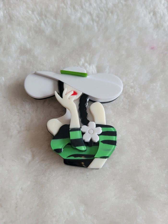 Broche femme au grand chapeau blanc