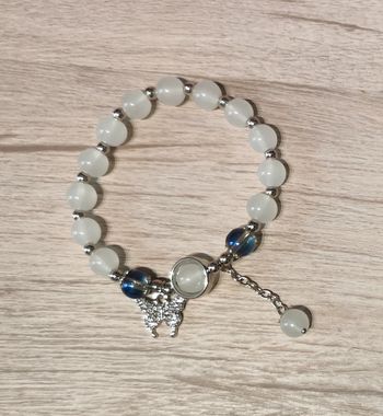 Bracelet élastique avec perles blanches et pendentif papillon argenté et zirconiums