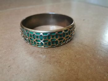 Bracelet en métal doré ajouré sur le fond vert