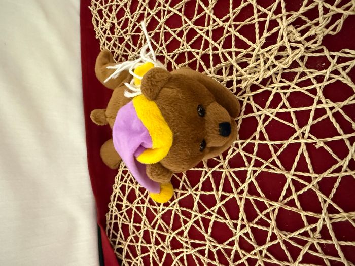 Doudou Ours brun marron couché Bonnet mauve POMMETTE