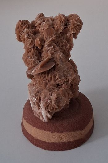 Roche minérale rose des sables sur un socle en pierre