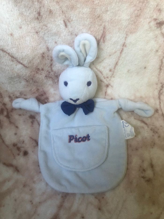 Doudou plat arrondi lapin bleu ciel blanc poche noeud Picot