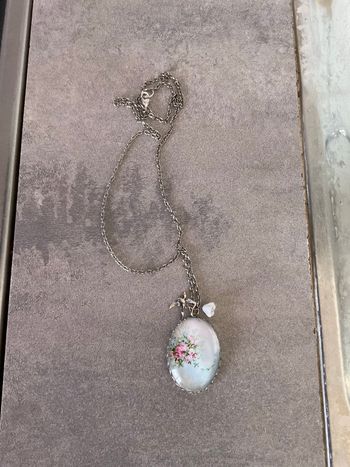 Collier couleur argent avec dessin fleurs roses et vertes à fond bleu ciel