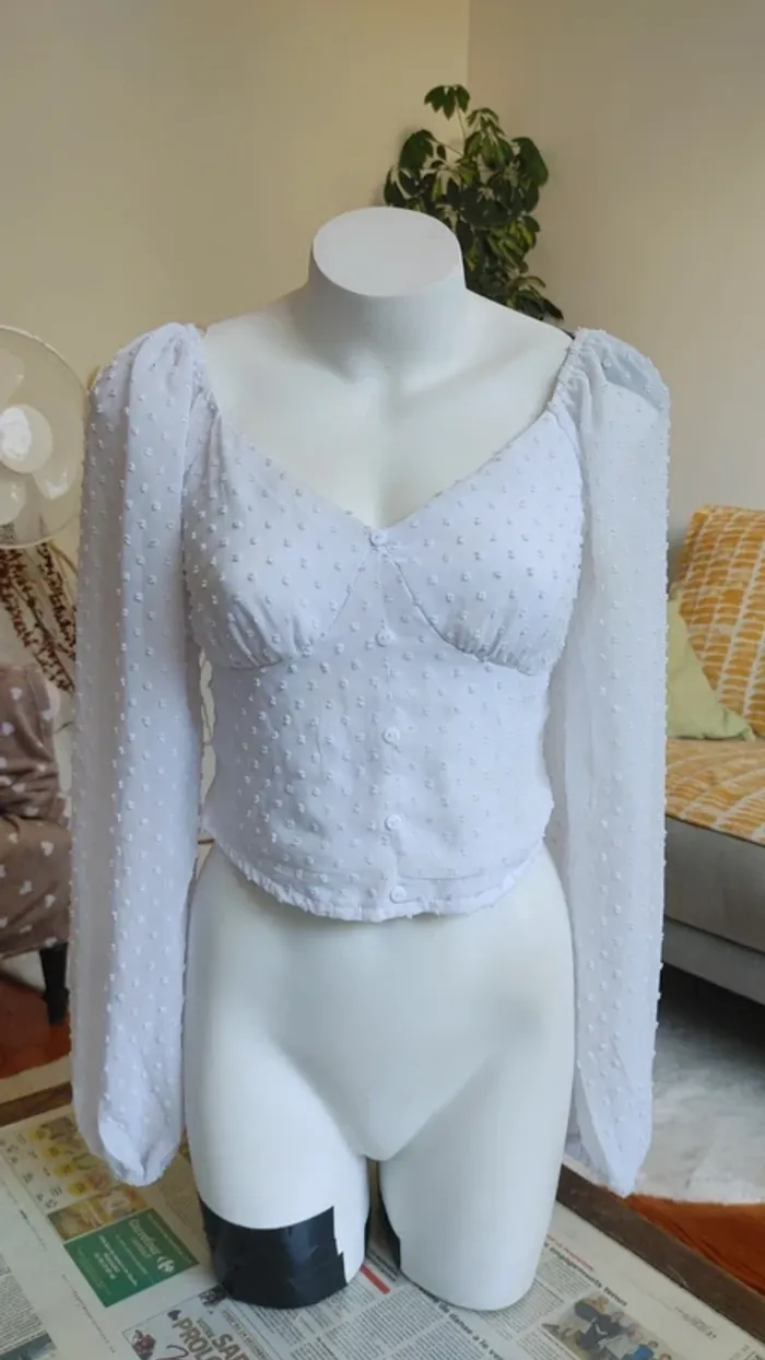 Blouse blanche à pois texturé manche légèrement bouffante décolleté