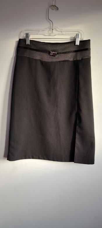 Jupe noire chic en tissu fluide, parfaite pour un look habillé ou professionnel. Détail décoratif “2