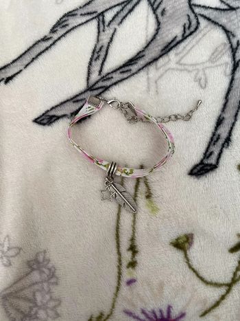 Bracelet en tissu avec breloques plume et étoile.