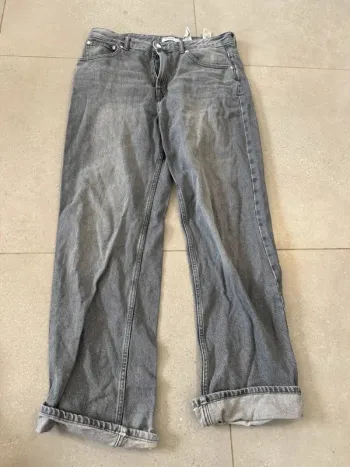 Jean gris Pull & Bear, taille 42, bon état mais il y a des trous en bas des jambes, 46x115cm