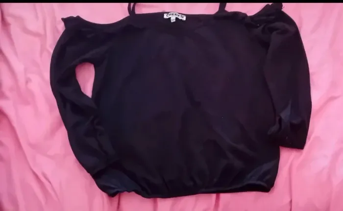 Très joli petit pull noir a bretelles épaule dénudées en très bon état creeks 12 ans