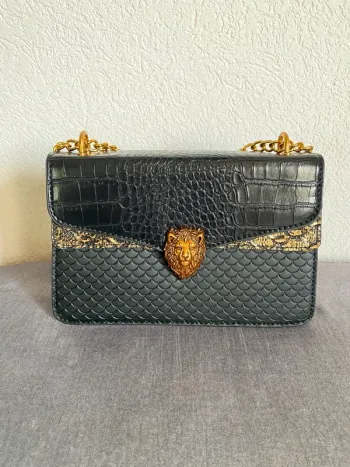 Sac en similicuir noir avec effet croco et détails dorés.